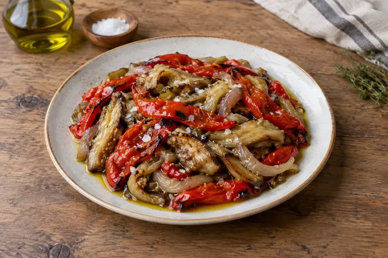 Strips of smoky roasted aubergine, red pepper and onion glistening with olive oil on bread